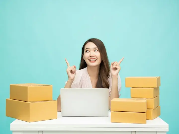 A woman on her laptop surrounded by moving boxes